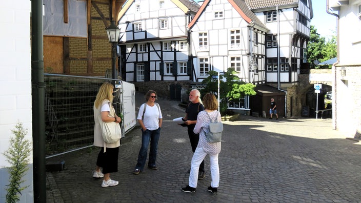 Die Gruppe der "Flunker-Tour" steht in der Altstadt und wertet den Gesamt-Punktestand aller Teilnehmer aus