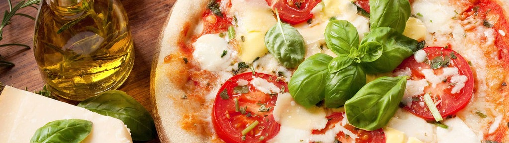 Symbolbild einer Pizza mit Tomaten, Mozarella und Basilikum.