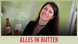 Bier Sommelière Jutta Knoll posiert mit einer Flasche und einem Glas Bier.