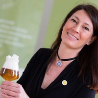 Bier Sommelière Jutta Knoll posiert mit einer Flasche und einem Glas Bier.