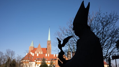 Denkmal für Kardinal Kominek, der in der ausgestreckten Hand eine Friedenstaube hält, auf der Sandinsel vor dem Breslauer Dom