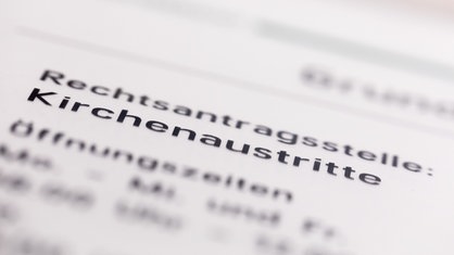 Ein Hinweisschild mit der Aufschrift "Kirchenaustritte" hängt vor der Rechtsantragsstelle im Oberlandesgericht. 