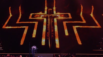 Ein riesiges flammendes Kreuz prägt das Bühnenbild bei einem Madonna-Konzert in Berlin 