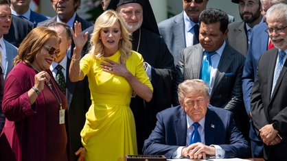 US-Präsident Donald Trump im Mai 2025. Er ist umringt von religiösen Führern. Evangelikale Predigerinnen beten. 