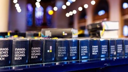 Eine Reihe von blauen Evangelischen Gesangbüchern in einer Kirche in München