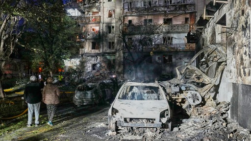 Anwohner gehen nach einem russischen Raketenangriff zwischen den Trümmern, Kiew, Ukraine, 19.07.2026.