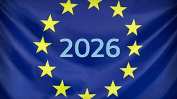 Auf einer Europaflagge steht "2026" in der Mitte zwischen den Sternen.