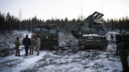 Zwei gepanzerte Raketenwerfer-Fahrzeuge stehen im November 2024 im winterlichen Rovajärvi in Finnland während einer NATO-Übung.