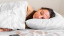 Young woman goes to sleep Phone addiction, insomnia. try to fall asleep. Sleep tracking on the phone. Circadian rhythm.