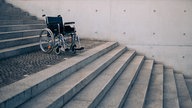 Rollstuhl steht auf einem Treppenabsatz