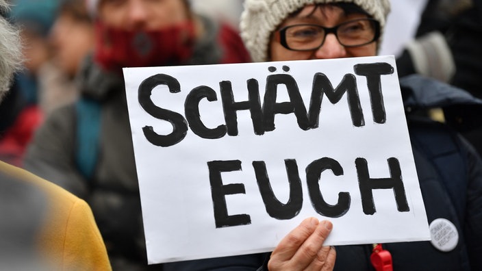 Eine Menschenmenge demonstriert am 06.02.2020 vor dem Thüringer Landtag - eine Frau hält ein Schild in Händen: "Schämt Euch"
