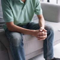 Ein Patient sitzt auf einer Couch, gegenüber sitzt ein Therapeut und macht sich Notizen