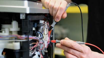 Reparatur an einem Kaffee-Vollautomaten.