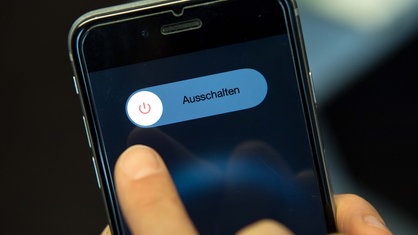 Symbolbild: Auf einem Smartphone-Display steht "Ausschalten" neben dem entsprechenden Icon.