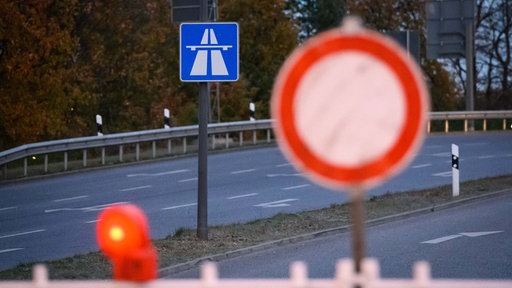 Symbolbild: Vor einem Autobahnhinweis steht ein "Einfahrt-Verboten"-Schild.