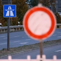Symbolbild: Vor einem Autobahnhinweis steht ein "Einfahrt-Verboten"-Schild.