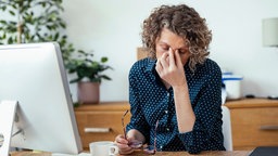 Eine Frau verzweifelt im Büro.