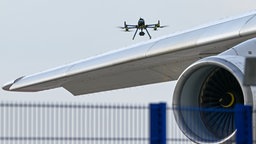 Eine Drohne der Polizei ist über einer Flugzeugtragfläche zu sehen. 