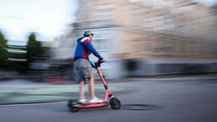 Ein Mann auf einem E-Scooter