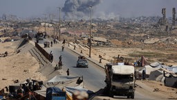 Binnenflüchtlinge im Gazastreifen, im Hintergrund große Rauchwolken (30.09.2025)