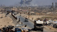 Binnenflüchtlinge im Gazastreifen, im Hintergrund große Rauchwolken (30.09.2025)