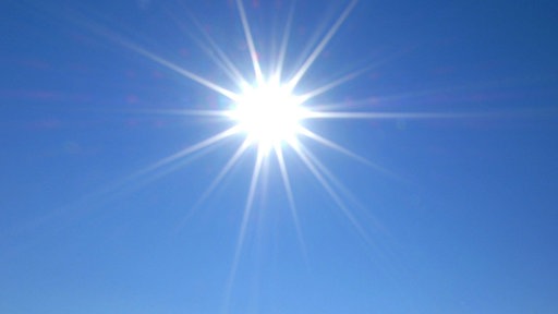 Symbolbild: Sonne am wolkenlosen Himmel im Gegenlicht.