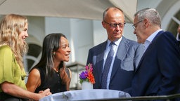Ruth Bosse (Ark Climate), Judith Dada (Langdock), Bundeskanzler Friedrich Merz (CDU) und Joerg Dittrich (Präsident des Zentralverbandes des Deutschen Handwerks) stehen während der Kabinettsklausur draußen im Gespräch.