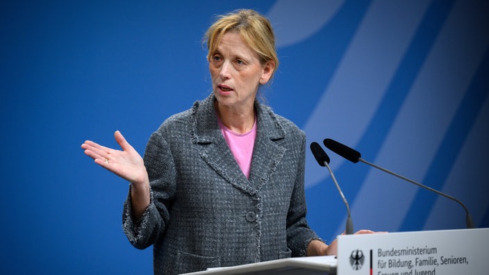 Karin Prien (CDU), Bundesministerin für Bildung, gestikuliert an einem Rednerpult. Sie stellt bei einer Pressekonferenz drei potenzielle Standorte für ein Holocaust-Bildungszentrum von Yad Vashem vor.