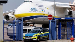 Polizeiwagen vor einem ukrainischen Flugzeug am Flughafen Leipzig (05.08.2026).