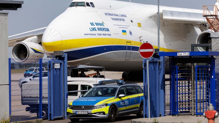 Polizeiwagen vor einem ukrainischen Flugzeug am Flughafen Leipzig (05.08.2026).