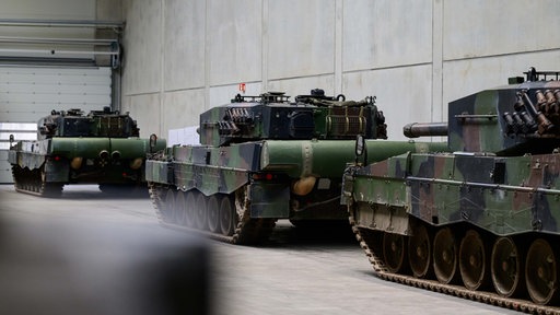 Kampfpanzer vom Typ Leopard 2A4 stehen in einer Halle von Rheinmetall.