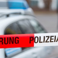 Polizeiabsperrband vor einem Polizeiwagen. Symbolbild