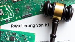 Auf einem Blatt mit der Überschrift "Regulierung von KI" liegen Computerchips und ein Richterhammer. Symbolbild