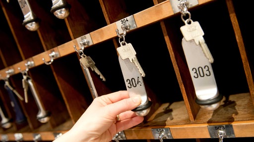 Hand greift nach Hotelzimmerschlüssel