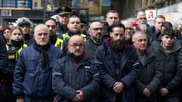Beschäftigte der Bahn und der Bundespolizei in Frankfurt/Main halten am 04.02.2026 eine Schweigeminute ab, um einem getöteten Zugbegleiter zu gedenken.