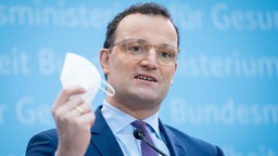 Archivbild: Jens Spahn hält bein einer Pressekonferenz eine FFP2-Maske in der Hand (2021).