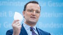 Archivbild: Jens Spahn hält bein einer Pressekonferenz eine FFP2-Maske in der Hand (2021).