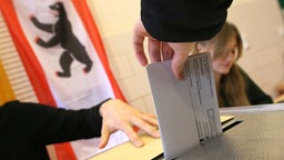 Eine Frau wirft ihren Wahlzettel für die Wahl zum Berliner Abgeordnetenhaus in die Wahlurne.