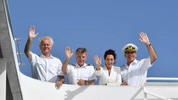 Symbolbild: Szene aus der Serie "Das Traumschiff" -  Barbara Wussow, Sascha Hehn,  Nick Wilder und Harald Schmidt winken an Bord (2018).