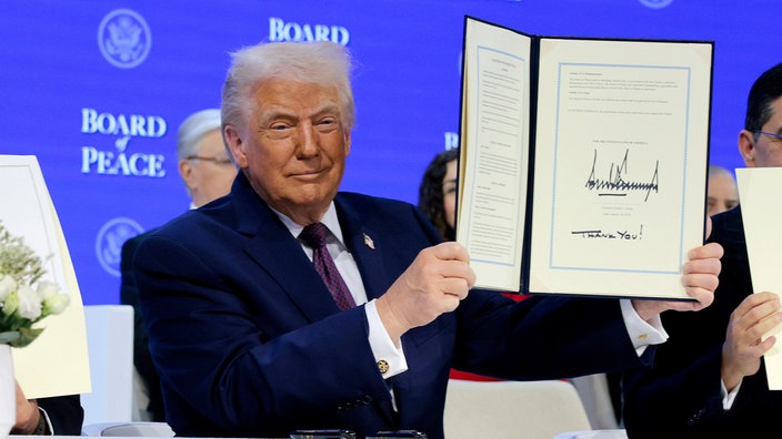 Donald Trump beim Wirtschaftsforum in Davos hält das Gründungsdokument zu seinem "Friedensrat" in den Händen.