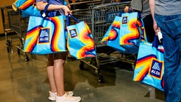 Menschen mit Aldi-EInkaufstüten in einem Markt in New York