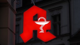 Beleuchtetes Apothekenzeichen in der Nacht