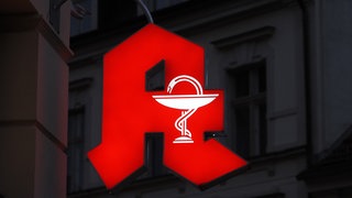 Beleuchtetes Apothekenzeichen in der Nacht