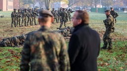 Verteidigungsminister Boris Pistorius (SPD) sieht in der Kaserne des Heimatschutzregiments 2 Soldaten in der Grundausbildung bei einer Übung mit Waffen zu.