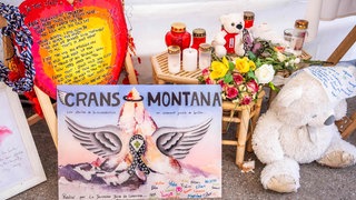 Kerzen und Karten zum Gedenken der Opfer von Crans-Montana