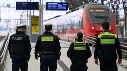 Mitarbeiterinnen der DB-Sicherheit und der Polizei an einem Bahnhof.
