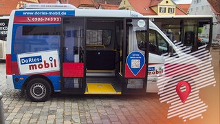 Ein kleiner Bus in weiß, blau und rot mit der Aufschrift "DoRies-mobil" – über die rechte Seite des Bildes wurde die Darstellung einer Deutschlandkarte gelegt, mit einer Markierung auf den ungefähren Standort des Bayrischen Rundfunks.