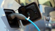 Nahaufnahme eines Kabels, dass in einem E-Auto steckt.