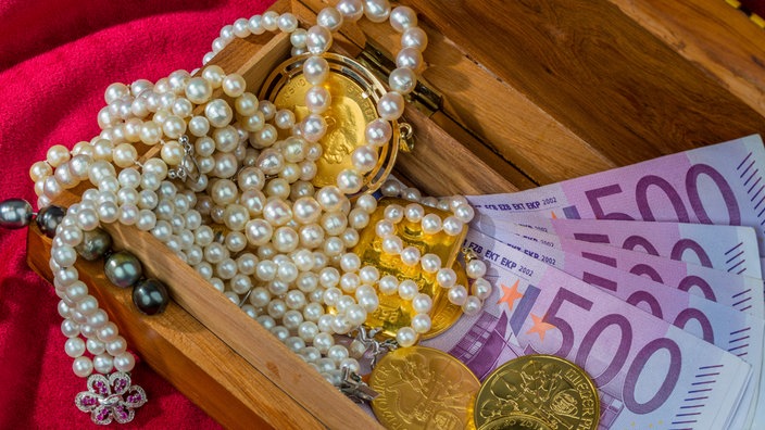 Holzschatulle mit Perlenkette, Schmuck auf Geldscheinen
