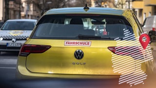Ein gelbes Fahrschulschild auf einem Autodach